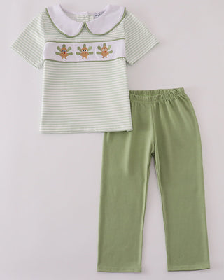 Children's outfit with striped shirt and green pants on a light gray background