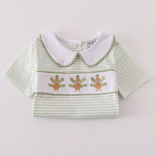 Green striped shirt with white collar and embroidered design on a light gray background