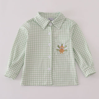 Green checkered shirt with a embroidered design on a light gray background