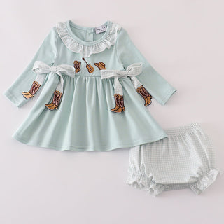 Baby’s outfit with light blue top and gingham bloomers on a light gray background