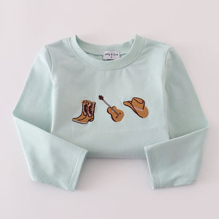 Light blue top with embroidered boots and guitar folded on a light gray background