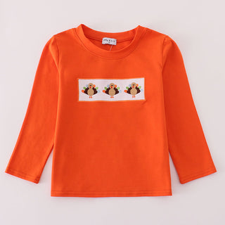Orange long-sleeve shirt with a graphic of three turkeys on a white background