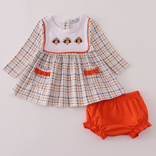 Baby top with plaid pattern and orange bloomers on a light gray background