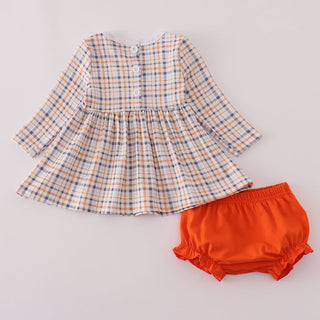 Plaid top and orange bloomers on a light gray background