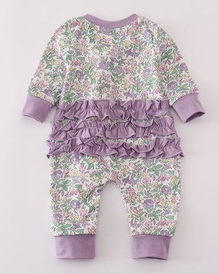 Floral baby outfit with ruffles on a light gray background