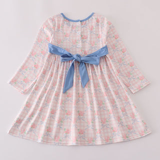Children's dress with a blue ribbon on a light gray background