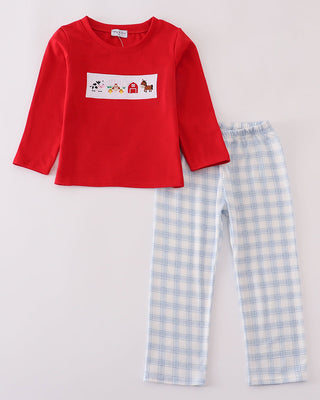 Red long-sleeve shirt with a graphic and blue checkered pants on a light gray background