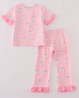 Pink pajama set with ruffled sleeves and pants on a light gray background