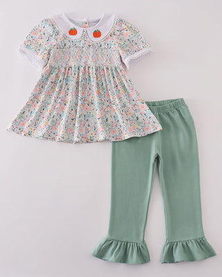 Floral top and green pants set on a light gray background