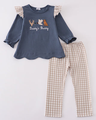 Children's outfit with blue top and checkered pants on a light gray background