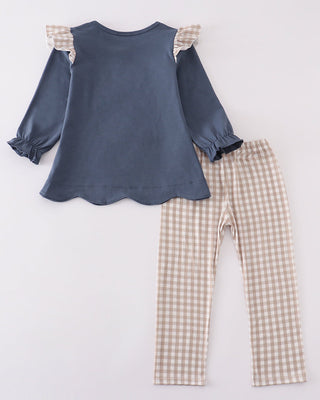 Children's outfit with blue top and checkered pants on a white background