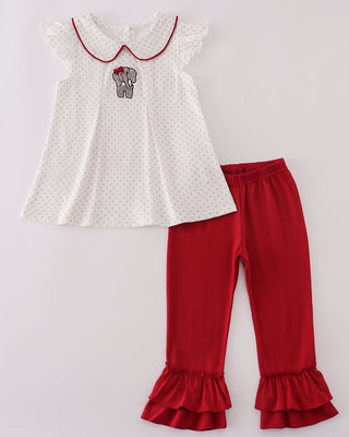 White top with red trim and red ruffled pants on a light gray background