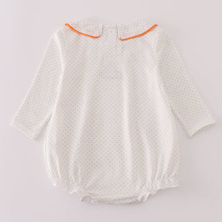 White baby romper with orange trim on a light gray background