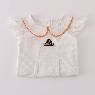 Folded girl outfit with ruffled collar and embroidered design on a light gray background