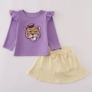 Purple top with tiger design and yellow checkered skirt on a light gray background