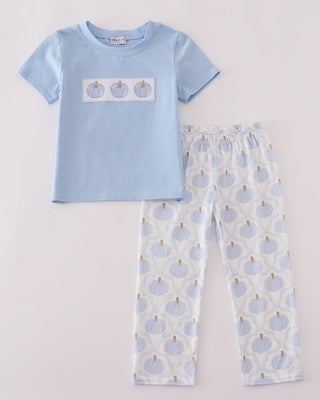 Children's pants set with blue t-shirt and patterned pants on a light gray background