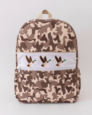 Camouflage-patterned backpack with embroidered designs on a white background