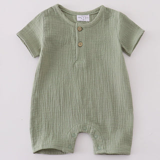 Green baby romper with buttons on a light gray background