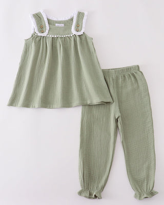 Green top and pants set on a white background