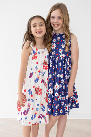 Two young girls wearing floral dresses on a white background