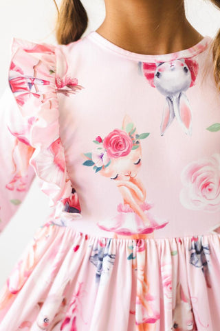 Pink dress with floral and ballerina prints on a white background