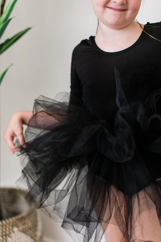 Child wearing a black leotard with tutu