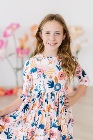 Young girl wearing a floral dress with a blurred floral background