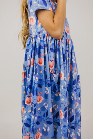 Blue floral dress worn by a person on a plain background