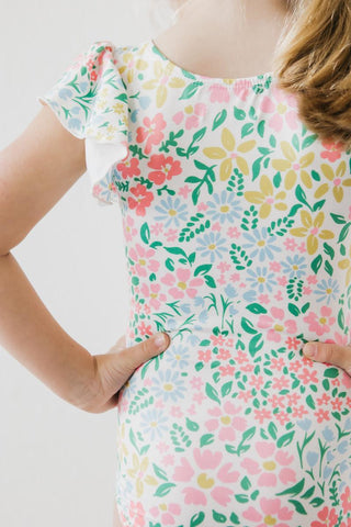 Child wearing a floral leotard with a white background