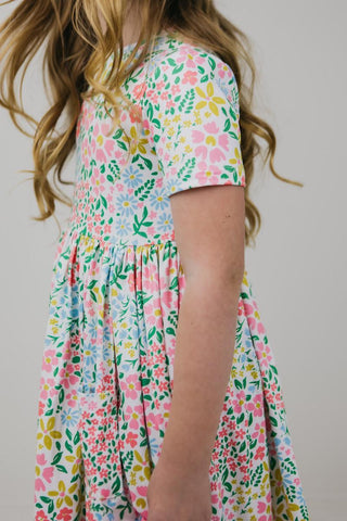 Child wearing a floral dress with a plain background