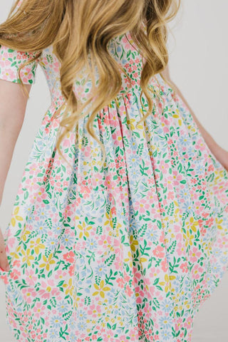 Girl wearing a floral dress with a plain background