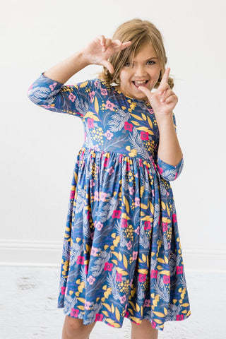 Young girl wearing a colorful floral dress on a white background