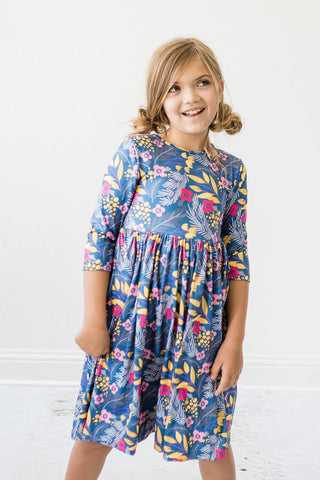 Young girl wearing a blue floral dress against a white background