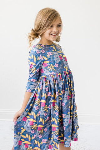 Young girl wearing a blue floral dress against a white background