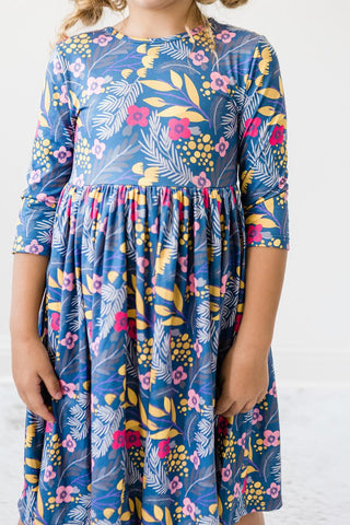 Child wearing a blue floral dress on a white background