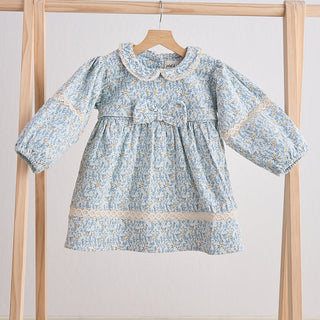 A blue floral corduroy lace dress for toddlers hanging on a wooden hanger against a white background.
