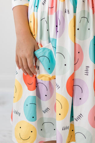 Colorful fabric with smiley face patterns and 'Happy' text, held by a person.