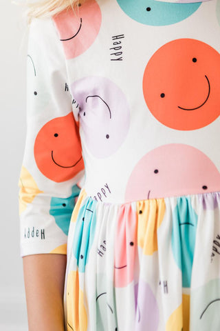 Colorful dress with smiley face patterns on a plain background