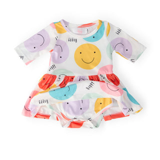 Children's dress with colorful smiley print on a white background