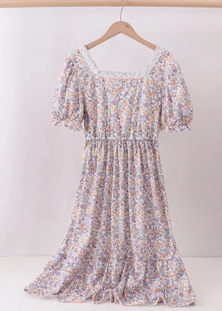 Floral dress on a hanger against a white background