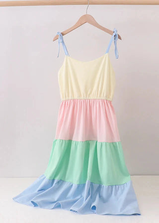 Color-blocked dress with pastel colors on a hanger against a white background