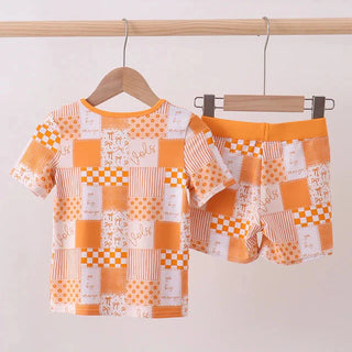 Patchwork shirt and shorts set on hangers against a white background