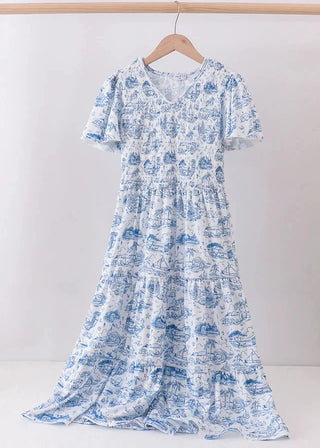 Blue and white patterned dress on a hanger against a white background