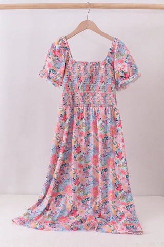 Floral dress on a hanger against a white background