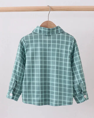 Green plaid shirt on a wooden hanger against a white background