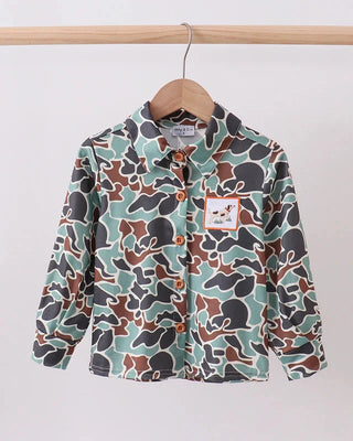 Camouflage-patterned shirt on a hanger against a white background