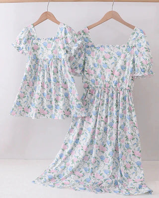 Floral dress on a hanger against a white background