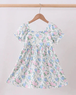 Floral dress on a hanger against a plain background