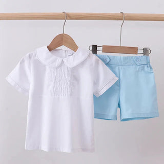 White shirt with a collar and light blue shorts on hangers against a white background