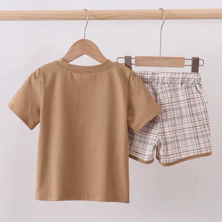 Brown t-shirt and plaid shorts on hangers against a white background